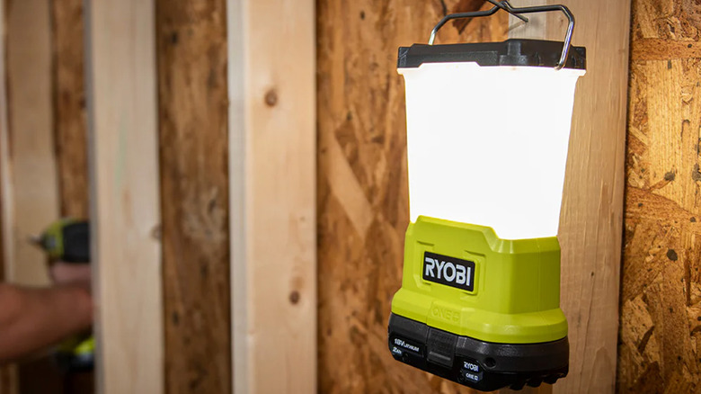 A Ryobi area light hanging on a wall stud and providing light.