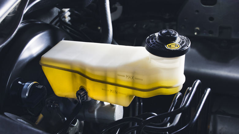 Brake fluid reservoir inside a car's engine compartment.