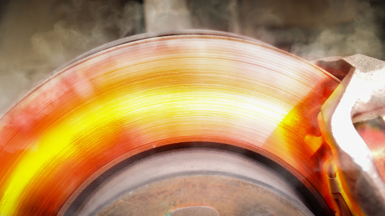 Red hot brake disk emitting smoke.