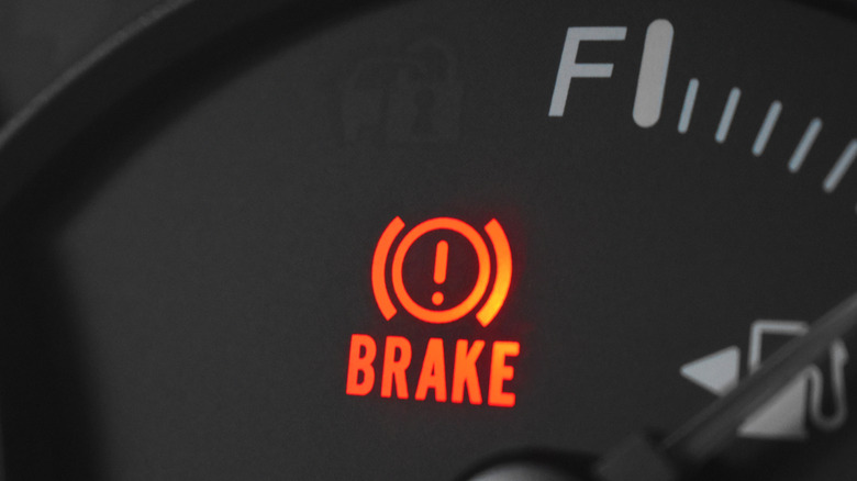 Brake warning light illuminated on a vehicle dashboard.