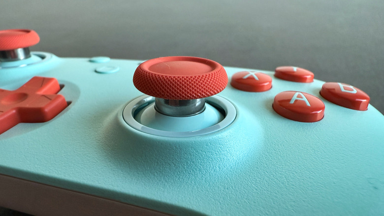 Close up of the thumbstick on a blue and orange controller