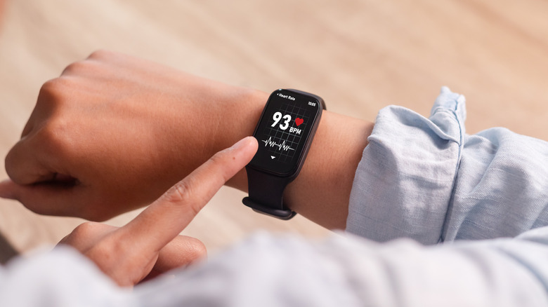 A person using a smart watch to measure their heart rate