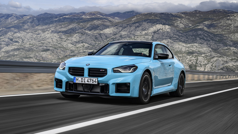 A blue 2027 BMW M2 driving