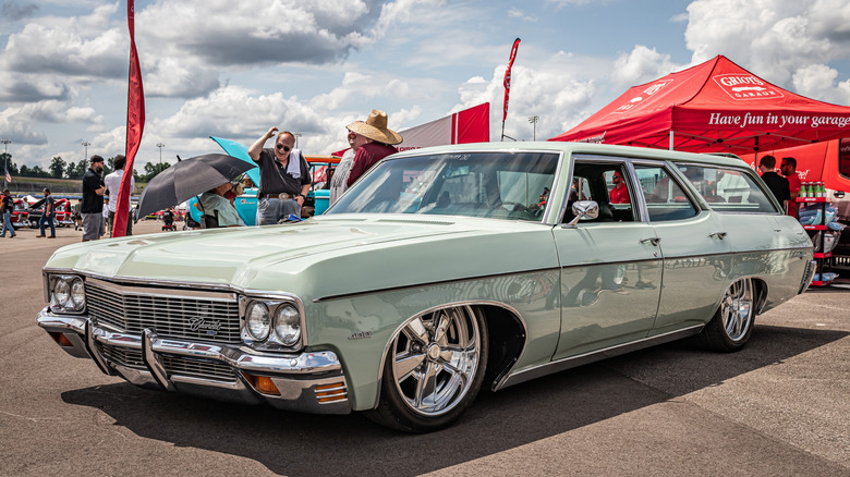 A low=perspective front-left corner view of a 1970 Chevrolet Kingswood Estate, finished in a pastel color, parked outside.