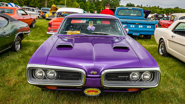 A high-perspective front view of a 1970 Dodge Super Bee with a B-body, finished in purple, standing on grass at a show.