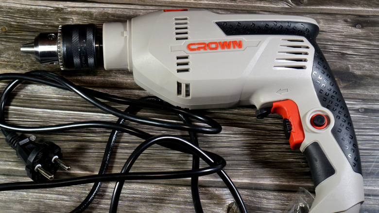 A white corded drill from Crown on a table.