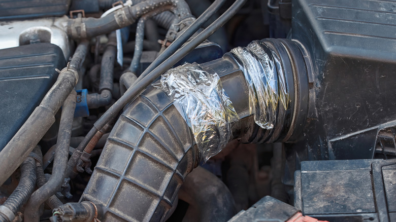 A duct tape holding together the air inflow pipe of a car.