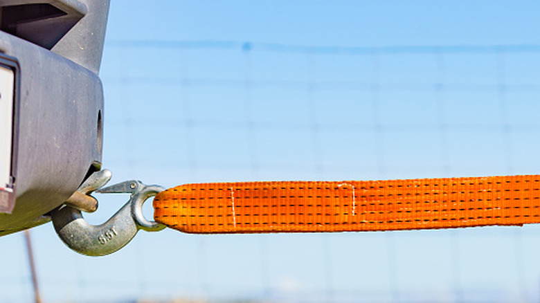 Tow hook with orange strap attached to it.