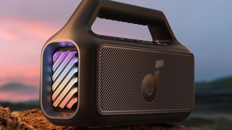 Anker Soundcore speaker with lights sitting on a natural surface with sunset behind