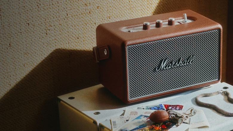 Brown Marshall speaker on a surface with photographs next to it