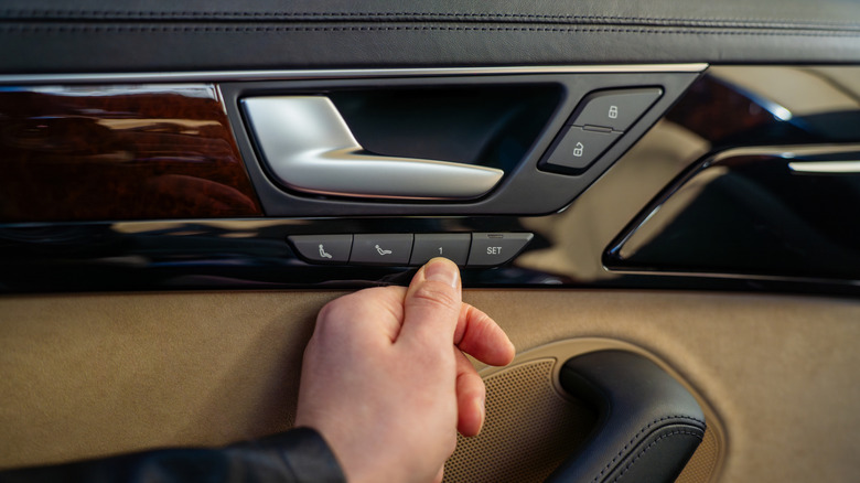 A driver tapping the "1" preset for their memory seat recall