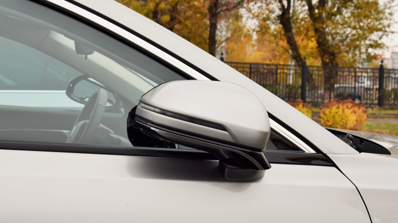 A car parked with the side mirror tucked in