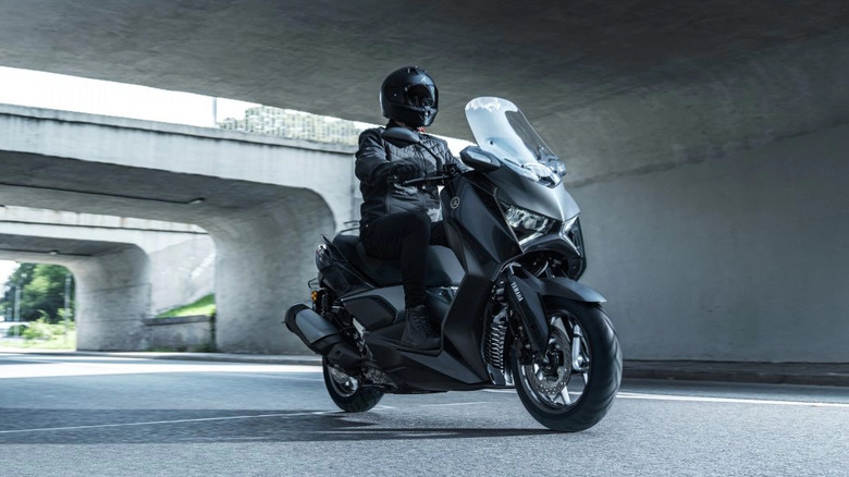 Yamaha XMAX Scooter being ridden under a bridge