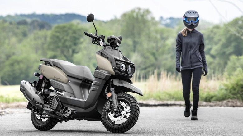 Yamaha Zuma 125 parked with a rider approaching