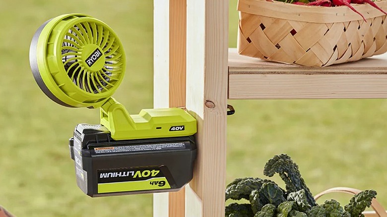 Ryobi fan mounted on a wooden rack where vegetable baskets are placed.