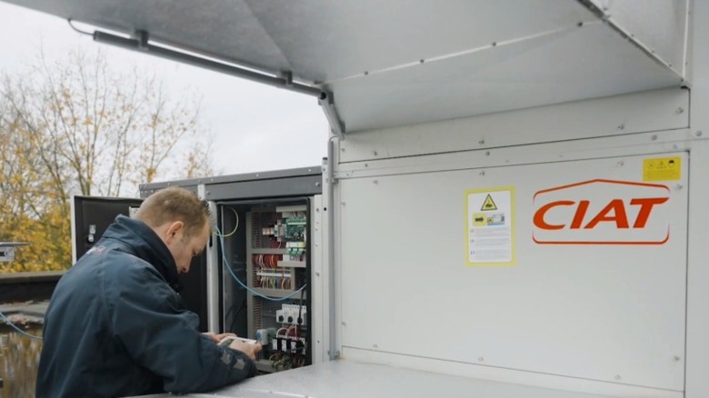 Technician working on a rooftop-mounted CIAT HVAC unit