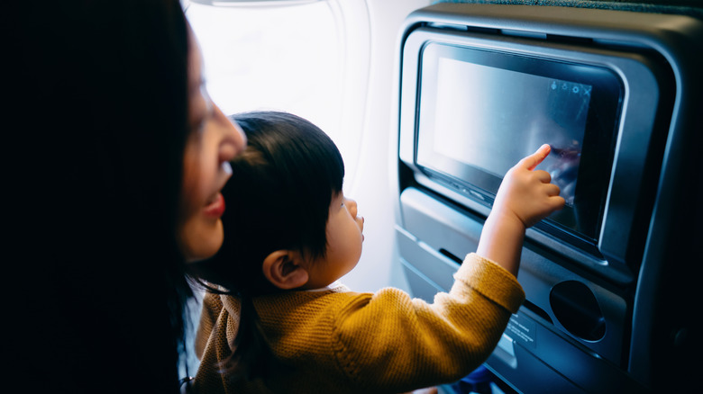 A child touching the screen on an IFE.