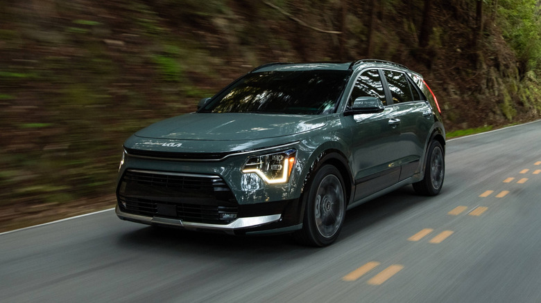 2026 Kia Niro Hybrid on a road through a forest
