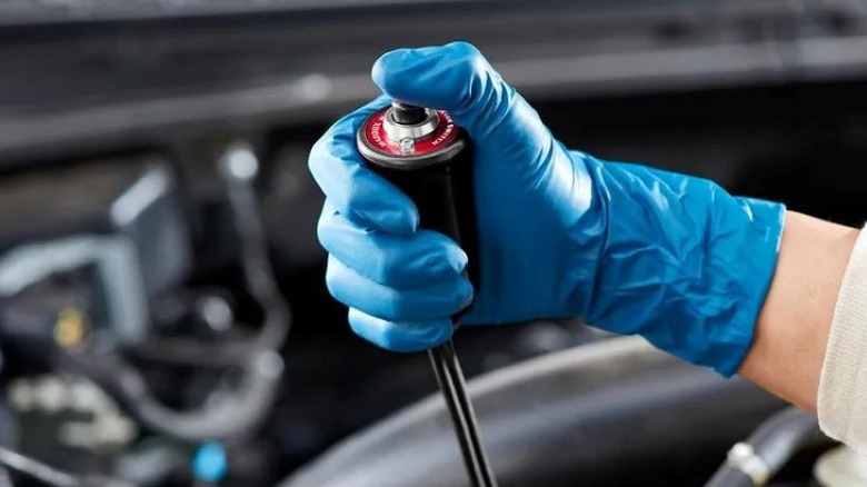Gloved hand pressing a button on a remote starter