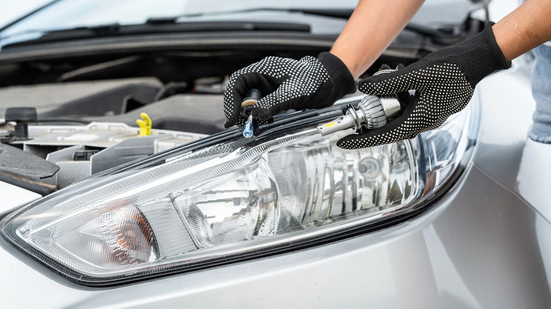 A person changing their headlights