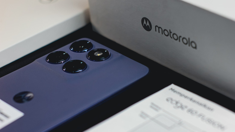 A Motorola Edge phone face-down beside the Motorola packaging.