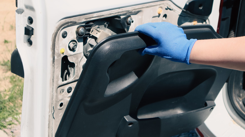 Hand pulling interior segment off a car door.