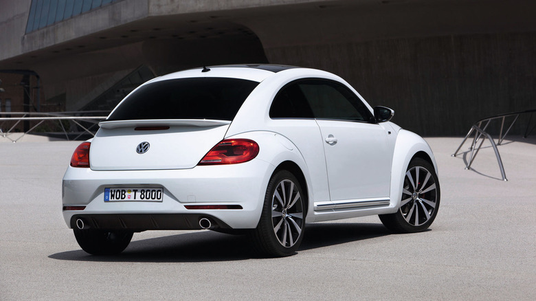 Rear and side view of a newer white Volkswagen Beetle
