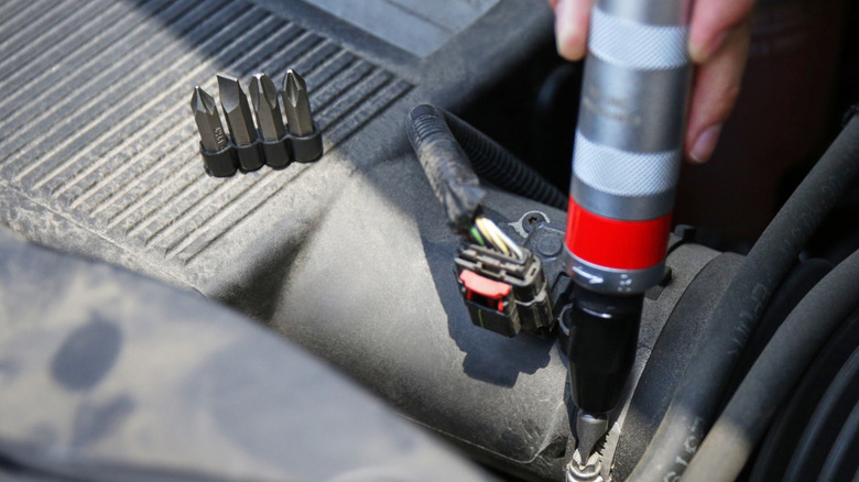 A person using a Craftsman 3/8-Inch Hand Impact Driver in a small space.