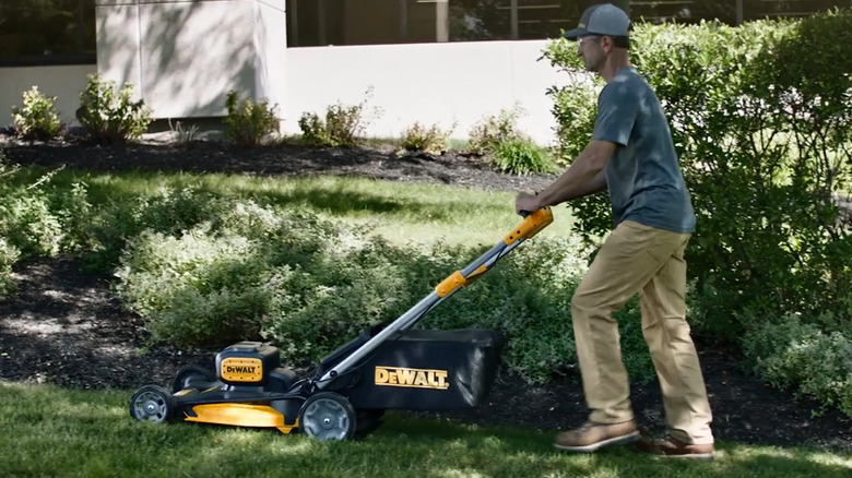 Person walking behind lawn mower