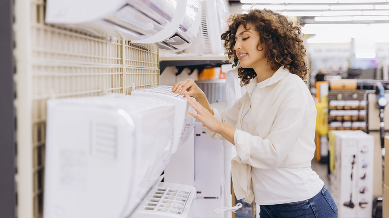 Person looking at mini split air conditioner units in a store