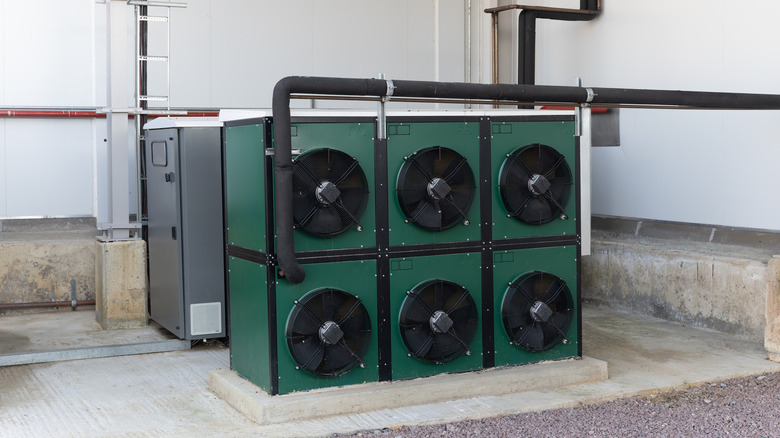Industrial-size air conditioner unit with four compressors outside a building