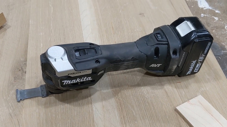 The Makita 18V LXT StarlockMax Oscillating Multi-Tool laid atop a wooden work surface