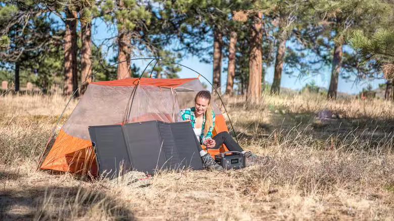 Camper in a camping tent with an EcoFlow solar panel.