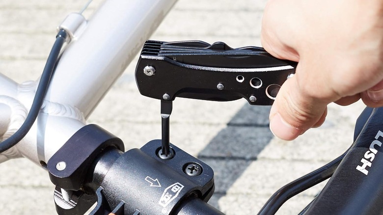 Amazon Basics Multitool being used to tighten a bike screw
