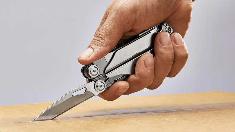 Gordon 20-in-1 multitool knife being used to open a cardboard box.