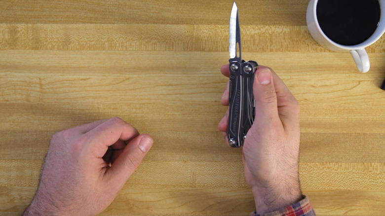 Man holding the Leatherman Wingman with the knife out