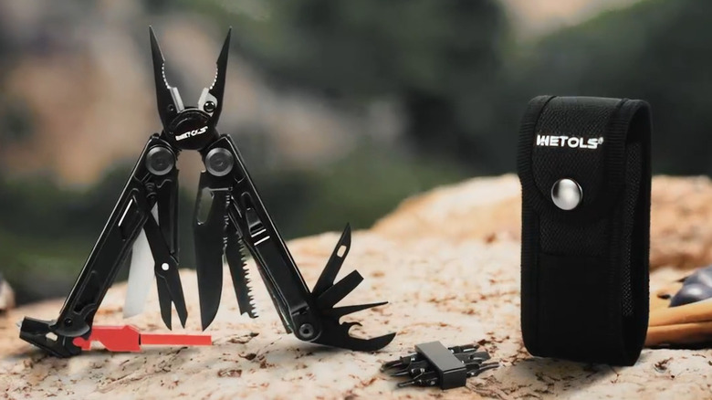 Wetols 21-in-1 multitool with the carrying pouch next to it on a rock