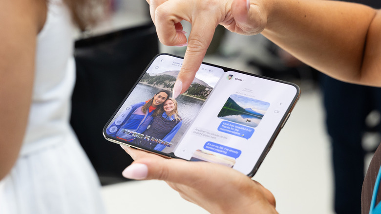 Woman holding an open iPhone Duo phone