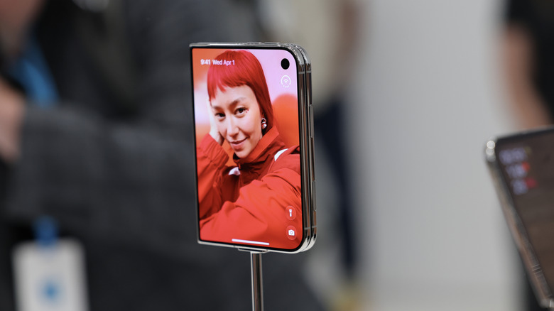 Folded iPhone Duo on display with front screen showing picture of a person