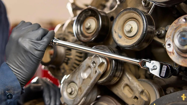 A mechanic using an Icon ratchet on an engine.