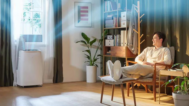 LG portable air conditioner next to a window with an illustration showing cool air moving throughout the room