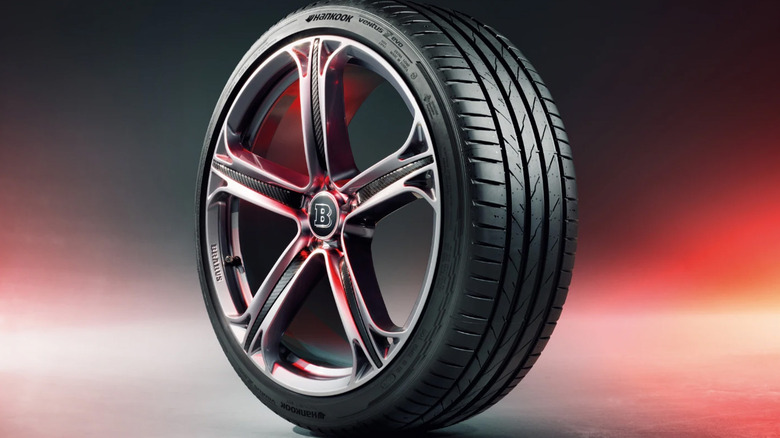A Hankook Ventus Evo tire on a concrete floor in a red and gray stylized background