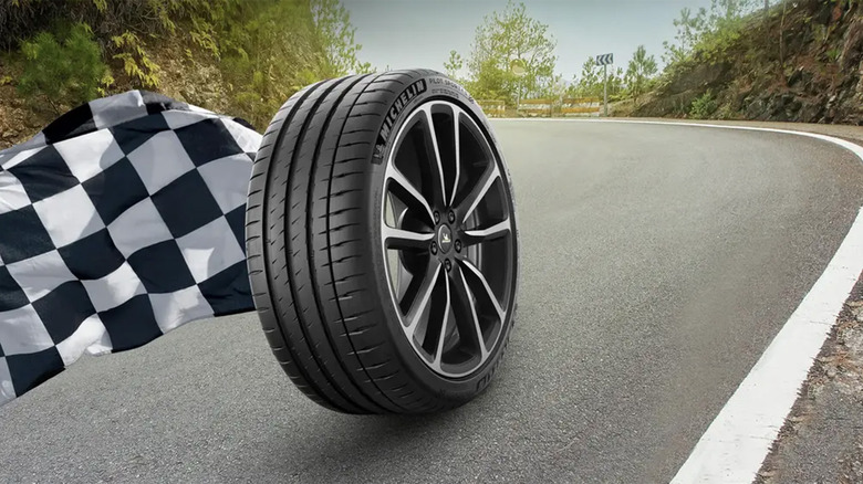 A Michelin Pilot Sport 4S tire enlarged on a hilly country road with a checkered flag