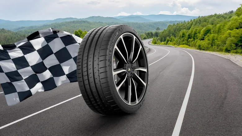 A Michelin Pilot Super Sport tire enlarged on a road with a checkered flag