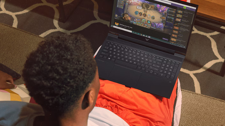 The HP Victus 16 laptop on the lap of a person sitting on a couch
