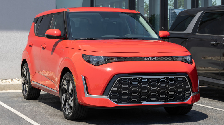 A 2025 Kia Soul GT Line crossover SUV finished in red on display outside a dealer lot.