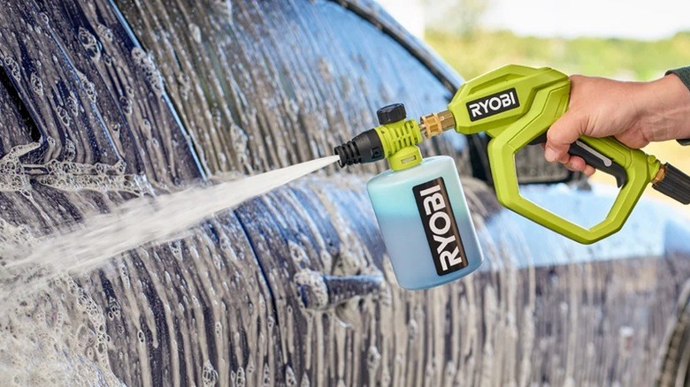 Person washing car with Ryobi pressure washer