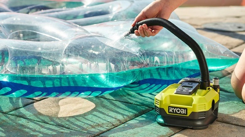 Person inflating pool toy with Ryobi inflator
