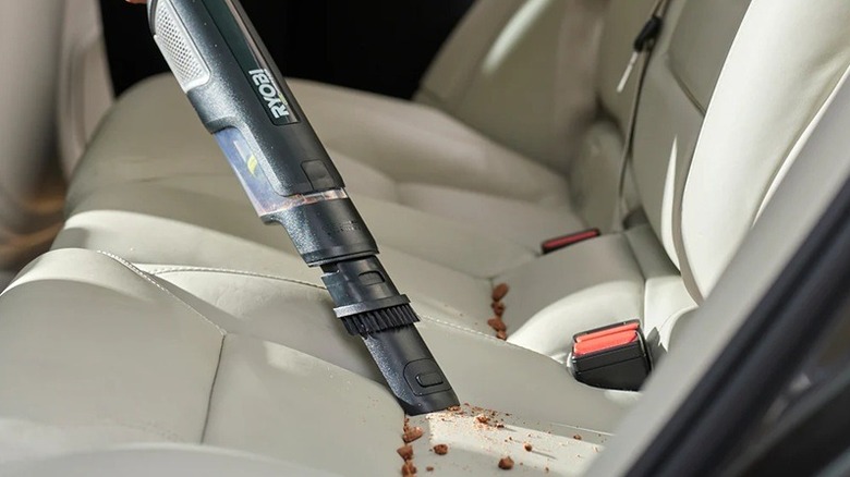 Person cleaning car with Ryobi vacuum