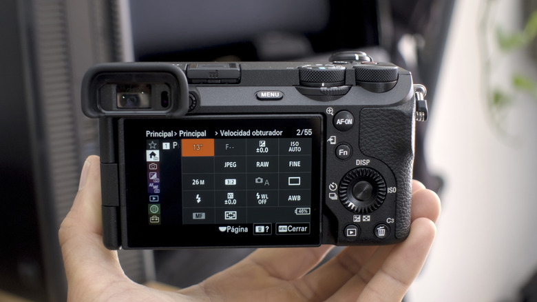 A person changing camera settings on the Sony a6700